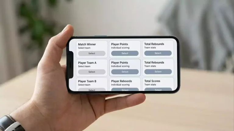 Hand holding a smartphone displaying a sports betting interface with multiple selections